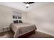 Comfortable bedroom with a bed, side table, window with blinds, carpet flooring, and a modern ceiling fan at 4937 N Granite Reef Rd, Scottsdale, AZ 85251