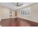 Inviting living room with wood floors, ceiling fan and bright natural light from the large windows with shutters at 4937 N Granite Reef Rd, Scottsdale, AZ 85251