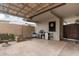 Covered patio area with brick fire pit and dart board for outdoor entertainment at 4937 N Granite Reef Rd, Scottsdale, AZ 85251