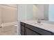 Well-lit bathroom featuring a dark wood vanity with quartz countertop and shower over tub at 25153 N 177Th Dr, Surprise, AZ 85387