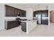 Modern kitchen featuring dark wood cabinets, stainless steel appliances, white countertops and an island with seating at 25153 N 177Th Dr, Surprise, AZ 85387