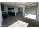 Open-concept living area with dark cabinets, wood-look tile, and sliding glass doors for indoor/outdoor living at 4317 E Bradford Ave, San Tan Valley, AZ 85143