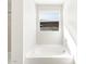 Bright bathroom featuring a soaking tub with tile surround and a window offering natural light, perfect for relaxation at 4832 N 177Th Dr, Goodyear, AZ 85395