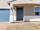 Inviting front entry with a covered porch, blue door, and stylish brick pathway at 4832 N 177Th Dr, Goodyear, AZ 85395