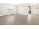 Neutral-toned room featuring wood-look tiled floors and a sliding glass door at 4832 N 177Th Dr, Goodyear, AZ 85395