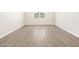 Neutral-toned room featuring wood-look tiled floors, bright white walls, and baseboards at 4832 N 177Th Dr, Goodyear, AZ 85395