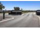 A welcoming entry gate to the community, beautifully designed with a dark color palette and lush landscaping, offering privacy and security at 4862 N 177Th Dr, Goodyear, AZ 85395