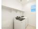 Well-lit laundry room featuring modern appliances, tile floors, and built-in shelving at 4862 N 177Th Dr, Goodyear, AZ 85395