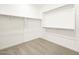 Walk-in closet with carpet flooring, custom shelving, and ample storage space at 4862 N 177Th Dr, Goodyear, AZ 85395