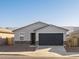 One-story home with gray siding, a dark gray garage door, and stone accents at 9121 N 173Rd Ln, Waddell, AZ 85355