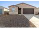 Tan house with brown garage door and stone accents at 9127 N 173Rd Ln, Waddell, AZ 85355