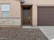 Brown front door with stone-accented entryway at 9127 N 173Rd Ln, Waddell, AZ 85355