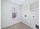 Laundry room with tile floor, window, and shelving at 10813 W Piute Ave, Sun City, AZ 85373