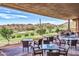 Relaxing outdoor seating area with tables and chairs, overlooking a golf course and desert landscape at 2740 W Plum Hollow Dr, Anthem, AZ 85086