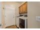 Convenient laundry room with washer, dryer, and cabinets at 30341 N Saddlebag Ln, San Tan Valley, AZ 85143