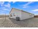 Backyard view of the house with gravel, small patio and air conditioning unit at 10810 W Torren Dr, Arizona City, AZ 85123