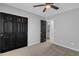 Carpeted bedroom with black closet doors and a glimpse of a well-lit bathroom at 10810 W Torren Dr, Arizona City, AZ 85123