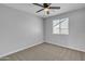 Cozy bedroom with soft carpet, a window with blinds, and a ceiling fan at 10810 W Torren Dr, Arizona City, AZ 85123