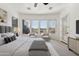 This sun-filled bedroom features a ceiling fan, a seating area by the bright windows, and plush carpeting at 12377 W Running Deer Ct, Peoria, AZ 85383