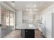 Bright kitchen with white cabinets, stainless steel appliances, island, and sliding glass door at 14862 W Laurel Ln, Surprise, AZ 85379