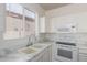 Well-lit kitchen area featuring a sink with modern faucet, and white cabinets at 14862 W Laurel Ln, Surprise, AZ 85379