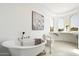 Luxurious white bathroom with a soaking tub, dual sinks, and arched windows at 5311 N Palo Cristi Rd, Paradise Valley, AZ 85253