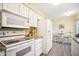 White kitchen with appliances and granite counters at 10606 W Granada Dr, Sun City, AZ 85373