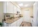 White cabinets, granite counters, and kitchen sink at 10606 W Granada Dr, Sun City, AZ 85373