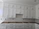 Elegant white kitchen cabinets with brushed nickel hardware, offering ample storage in a modern design at 1907 W Brooke Ln, Queen Creek, AZ 85144