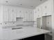 Bright kitchen showcasing white cabinetry, quartz countertops, and a sleek, dark island at 1907 W Brooke Ln, Queen Creek, AZ 85144