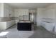 Spacious kitchen featuring white cabinetry, a center island, and tile flooring, awaiting final touches at 1907 W Brooke Ln, Queen Creek, AZ 85144