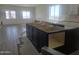 Open kitchen layout with dark wood island and tile flooring, ready for appliances and countertop installation at 1907 W Brooke Ln, Queen Creek, AZ 85144