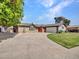 Charming single-story home with mature landscaping, green lawn, and a welcoming red front door at 8450 E Montecito Ave, Scottsdale, AZ 85251