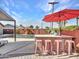 Outdoor kitchen with stainless steel grill, bar seating, red umbrella, and backyard view at 8450 E Montecito Ave, Scottsdale, AZ 85251