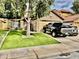 Attractive single-story home with a lush green lawn, mature shade tree, and a two-car garage at 4444 E Wildwood Dr, Phoenix, AZ 85048