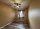 Bedroom with wood flooring and a ceiling fan and a window with brown curtains at 647 N Cambridge St, Gilbert, AZ 85233