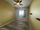 Bedroom with wood flooring and a ceiling fan and a window with blue curtains at 647 N Cambridge St, Gilbert, AZ 85233