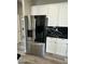 Stainless steel refrigerator with water dispenser next to white cabinets and black countertop at 647 N Cambridge St, Gilbert, AZ 85233