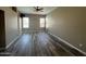 Large living room with wood flooring and a ceiling fan and windows on two walls at 647 N Cambridge St, Gilbert, AZ 85233