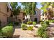 Exterior of a well maintained condominium with lush greenery and shaded walkways at 15380 N 100Th St # 1106, Scottsdale, AZ 85260
