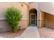 A charming condo entrance with an arched doorway, screen door, and desert landscaping at 15380 N 100Th St # 1106, Scottsdale, AZ 85260