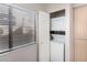 A laundry room shows a stacked washer and dryer with a window to the left with blinds at 15380 N 100Th St # 1106, Scottsdale, AZ 85260