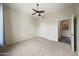 Bright bedroom with ceiling fan and view into the kitchen at 14575 W Mountain View Blvd # 11113, Surprise, AZ 85374