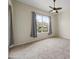 Bedroom features carpet flooring, ceiling fan, and a large window at 14575 W Mountain View Blvd # 11113, Surprise, AZ 85374