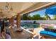 Covered patio with dining area overlooking the pool and spa, offering a perfect space for outdoor living at 5038 W Echo Ln, Glendale, AZ 85302