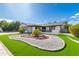Inviting single-story home with a lush lawn, desert landscaping, and a charming exterior at 5038 W Echo Ln, Glendale, AZ 85302