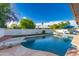 Backyard pool with diving board, lush landscaping, and ample space for relaxation and recreation at 5038 W Echo Ln, Glendale, AZ 85302