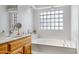 Bathroom with soaking tub, double vanity, and a large window at 14799 W Devlin Dr, Goodyear, AZ 85395