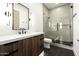 Sleek bathroom with a glass enclosed shower, dark hardwood vanity and modern fixtures at 28171 N 95Th St, Scottsdale, AZ 85262