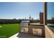 Outdoor kitchen with stainless steel grill, countertop, and manicured backyard at 28171 N 95Th St, Scottsdale, AZ 85262